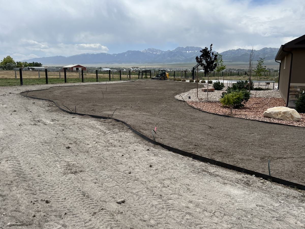 Landscaping build in progress, mountains backdrop