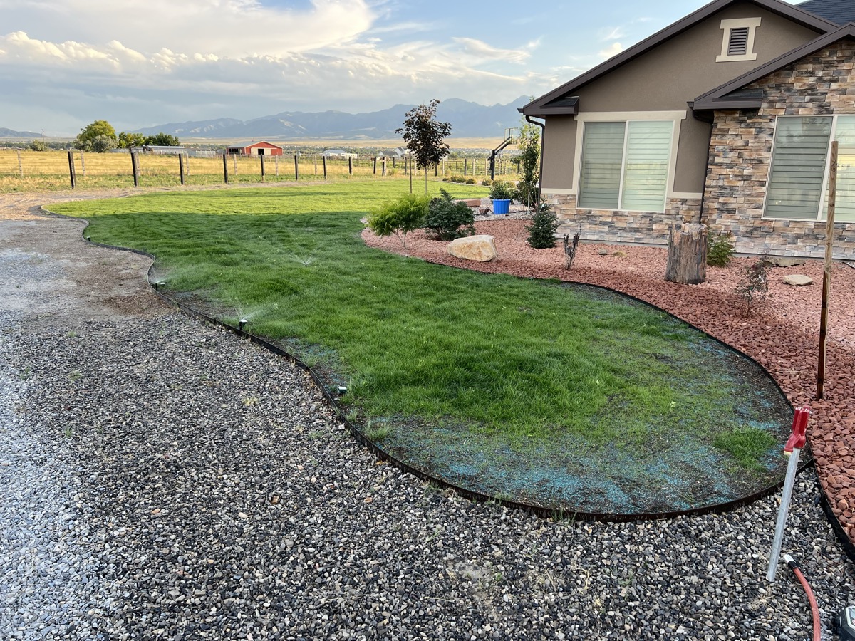 Curved lawn with rock border and Tooele valley views