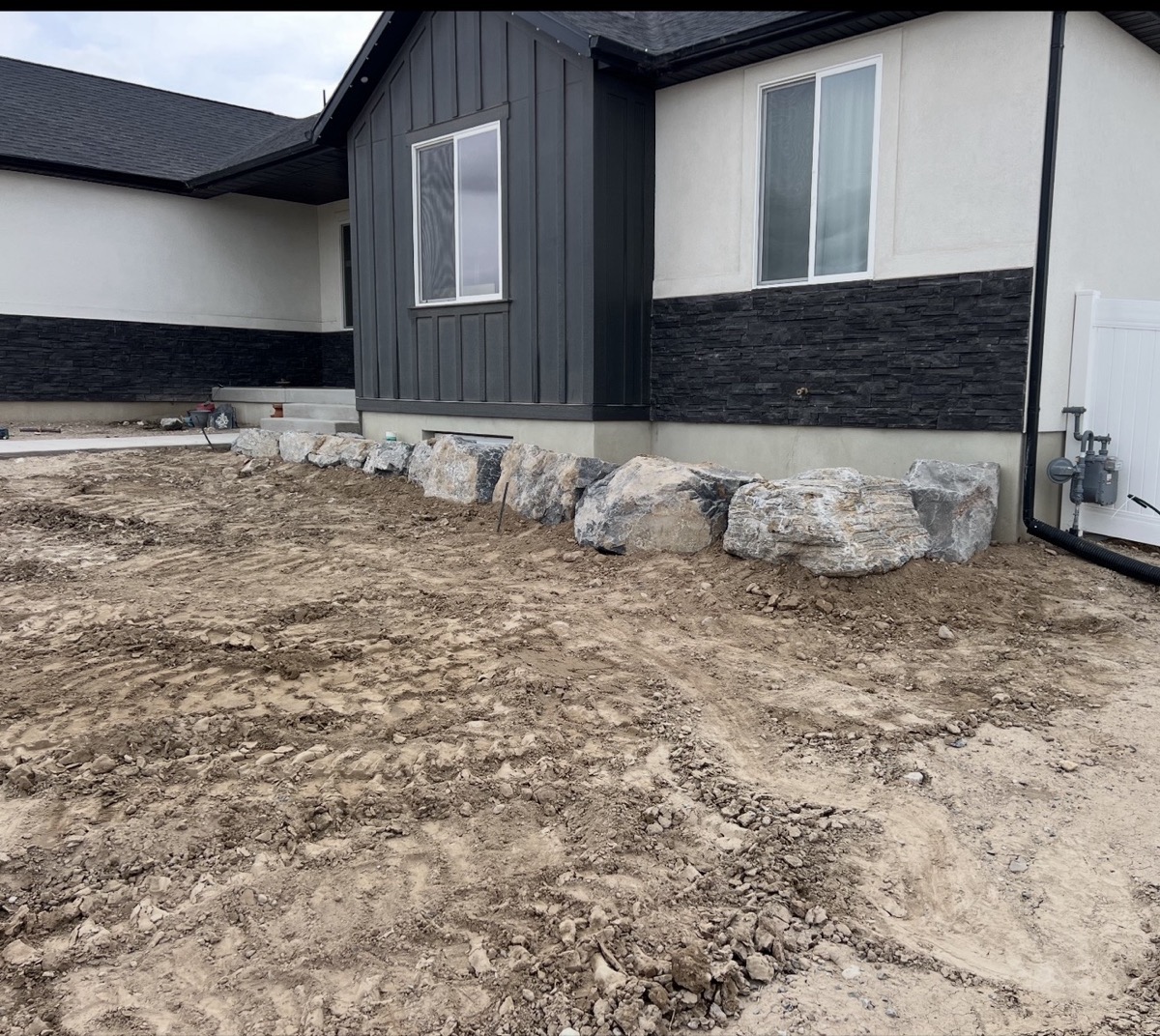 Boulder border retaining wall in landscape