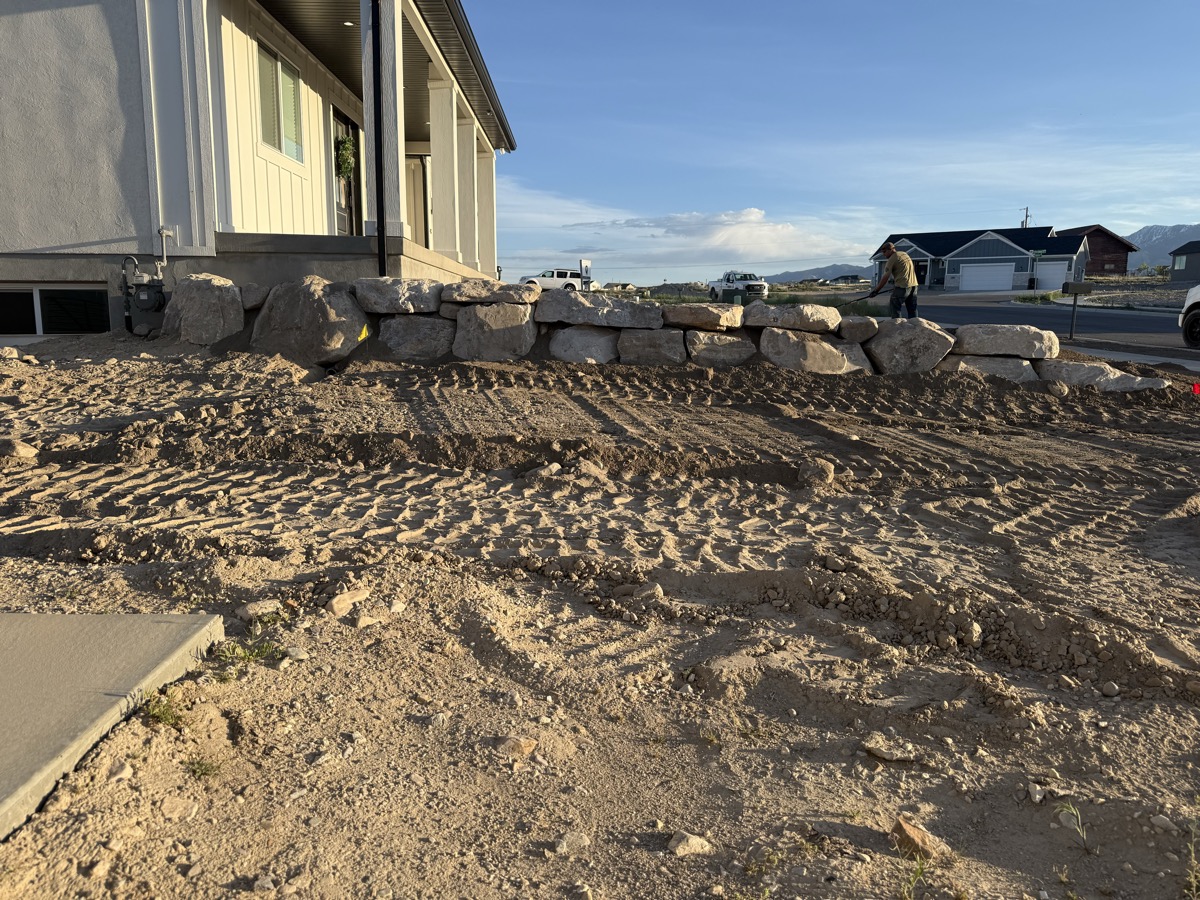 Boulder retaining wall along home frontage