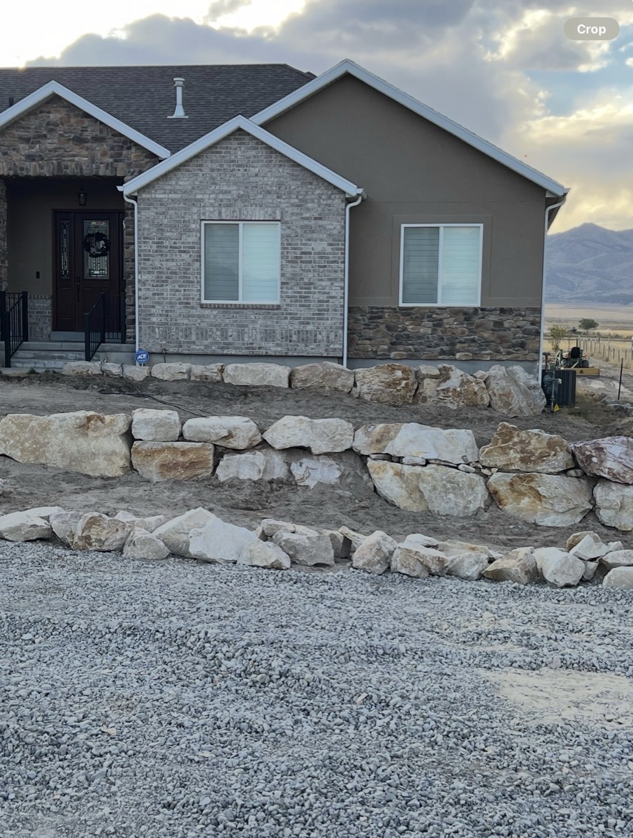 Boulder retaining wall along residential home