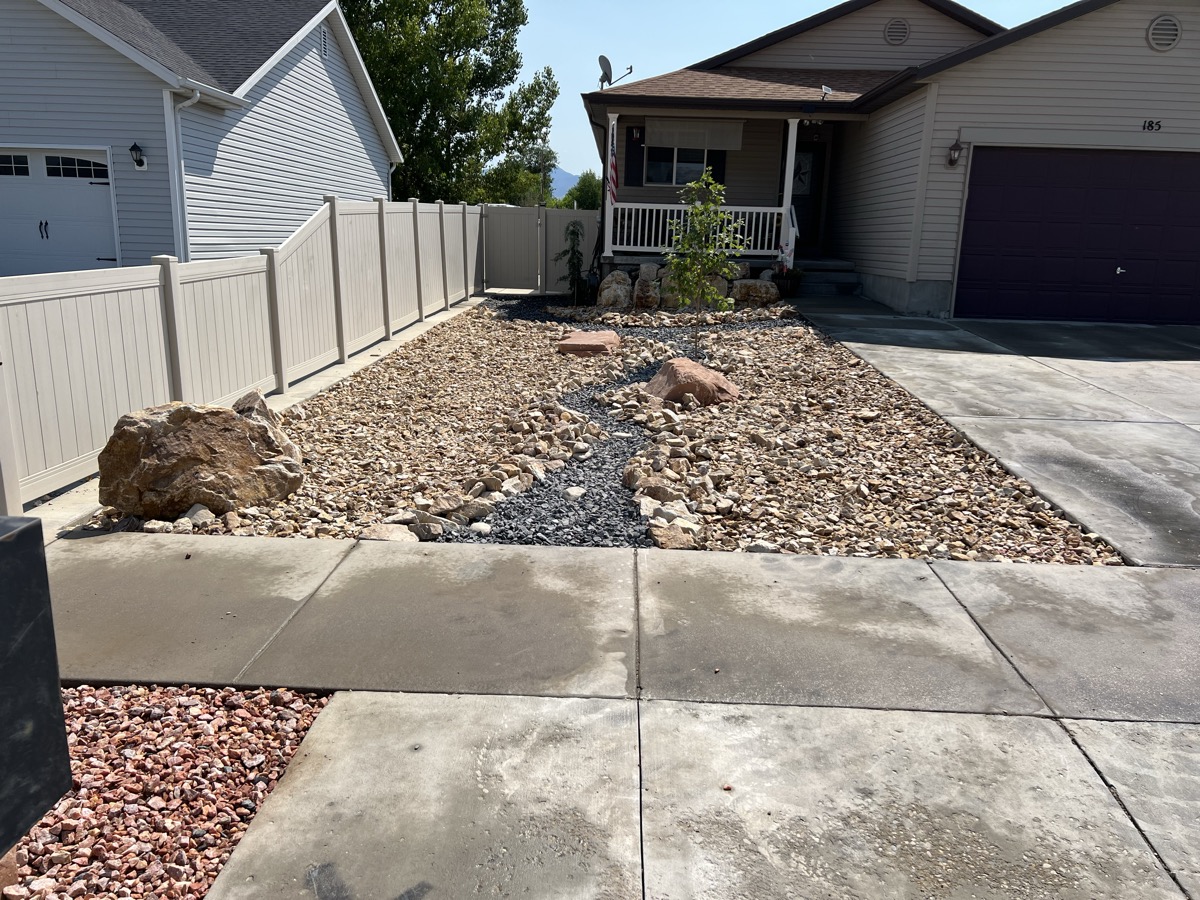 Dry creek bed xeriscape design with boulders and gravel