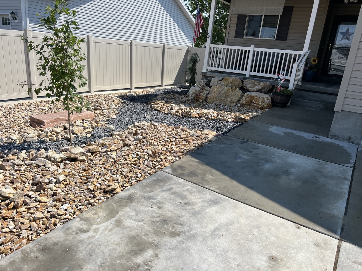 Rock and gravel xeriscape with boulders and concrete path